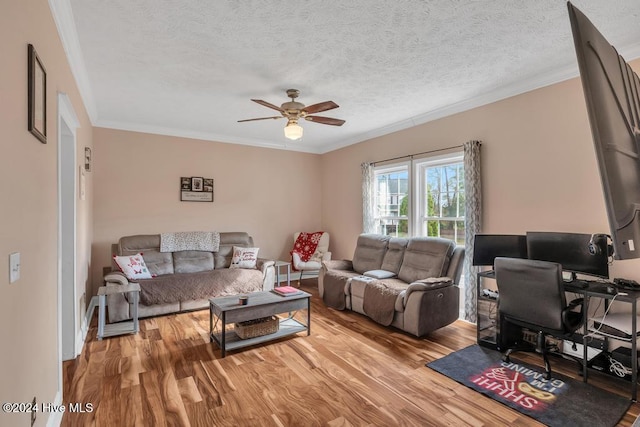 living room with hardwood / wood-style flooring, ceiling fan, ornamental molding, and a textured ceiling