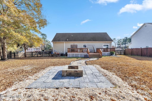 rear view of house with a patio, a fire pit, and a deck