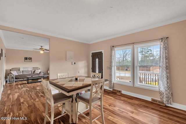 dining room featuring ceiling fan, hardwood / wood-style floors, and crown molding