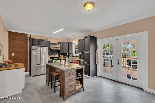 kitchen featuring a center island, french doors, pendant lighting, wooden walls, and appliances with stainless steel finishes