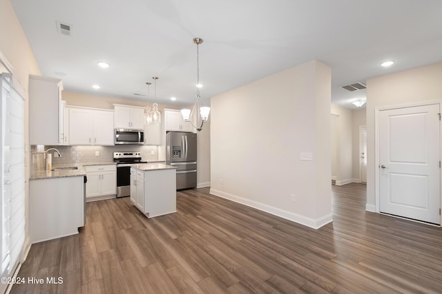 kitchen featuring sink, a center island, hanging light fixtures, dark hardwood / wood-style flooring, and appliances with stainless steel finishes