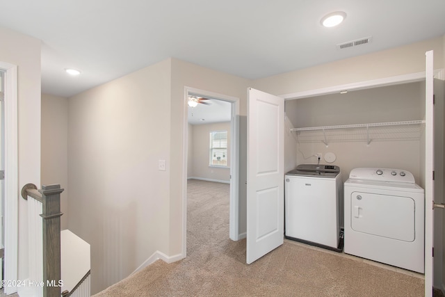 laundry room with light carpet, independent washer and dryer, and ceiling fan