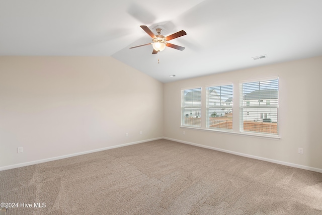 carpeted empty room with vaulted ceiling and ceiling fan