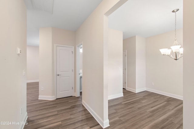 hall featuring a chandelier and dark hardwood / wood-style flooring