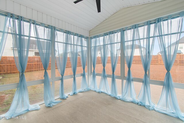 unfurnished sunroom with ceiling fan and vaulted ceiling