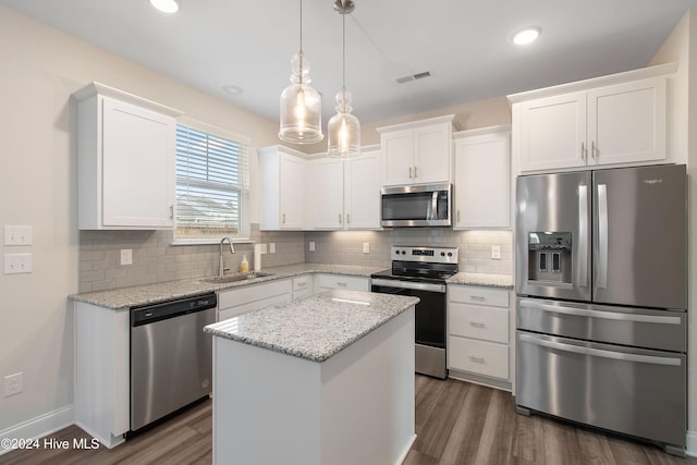 kitchen with sink, a center island, dark wood-type flooring, white cabinets, and appliances with stainless steel finishes