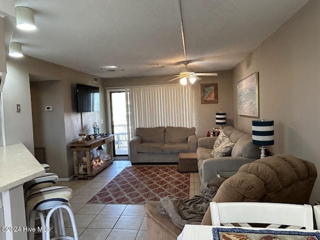 living room with light tile patterned floors, a textured ceiling, and ceiling fan