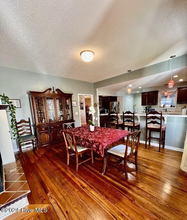 dining room featuring dark hardwood / wood-style flooring and a textured ceiling