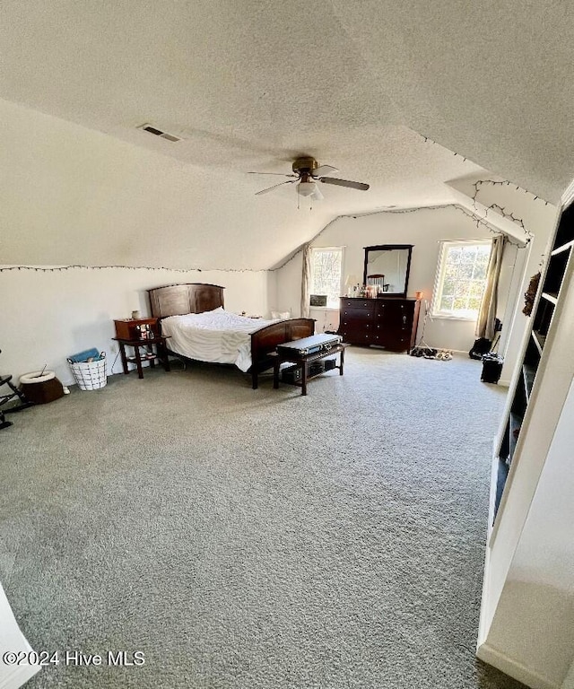 bedroom featuring carpet, ceiling fan, lofted ceiling, and a textured ceiling