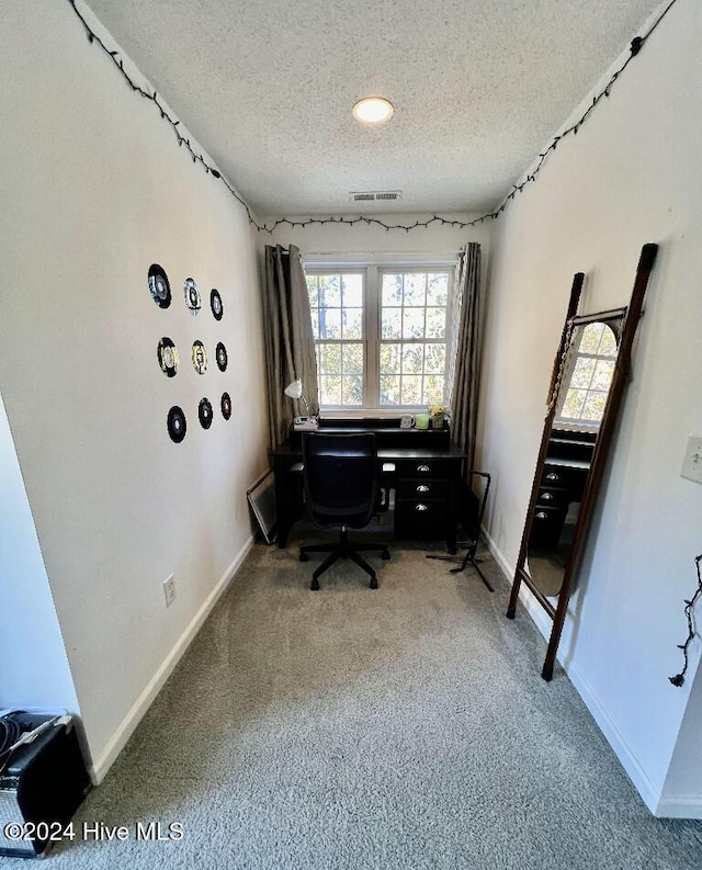 office area with carpet floors and a textured ceiling