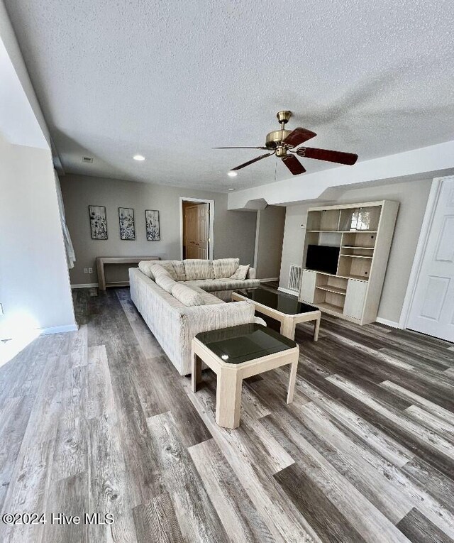 living room featuring wood-type flooring and a textured ceiling