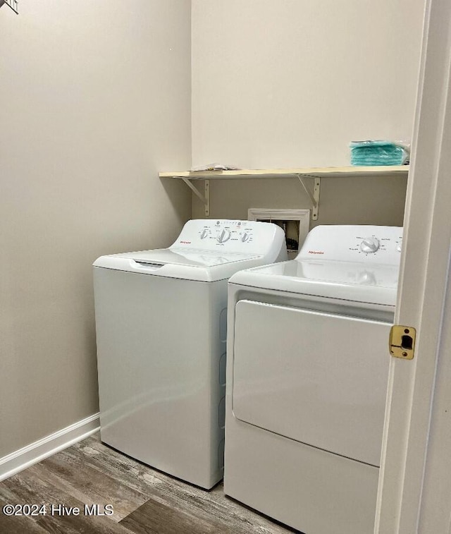 clothes washing area featuring wood-type flooring and washing machine and clothes dryer