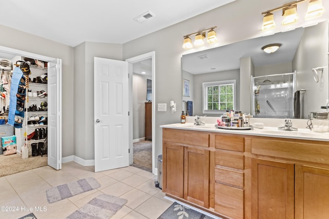 bathroom with tile patterned floors, vanity, and a shower with shower door