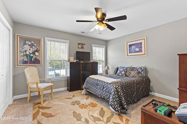 carpeted bedroom with ceiling fan and a closet