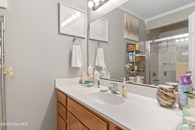 bathroom with crown molding, vanity, a shower with shower door, and toilet