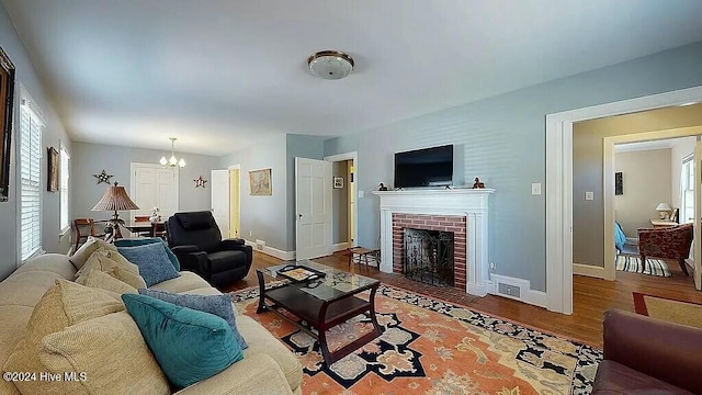 living room featuring a notable chandelier, wood-type flooring, and a fireplace