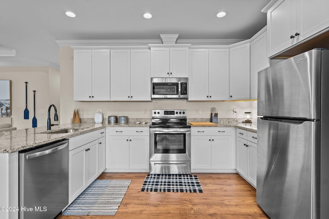 kitchen featuring sink, white cabinetry, stainless steel appliances, and light hardwood / wood-style flooring