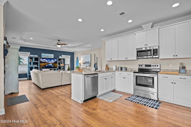 kitchen featuring light hardwood / wood-style flooring, ceiling fan, white cabinetry, kitchen peninsula, and stainless steel appliances