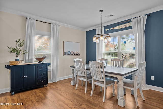 dining space featuring a chandelier, light hardwood / wood-style floors, and ornamental molding