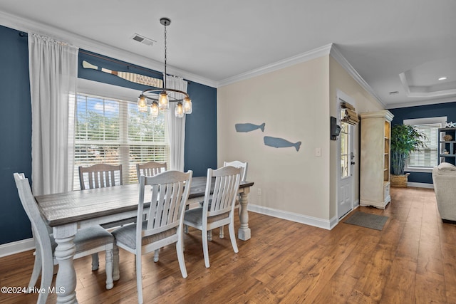 dining space featuring crown molding, hardwood / wood-style floors, and a notable chandelier