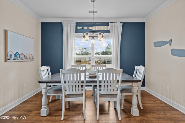 dining area with ornamental molding, an inviting chandelier, and dark wood-type flooring