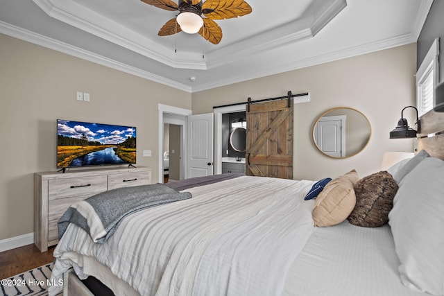 bedroom with ensuite bath, ceiling fan, crown molding, wood-type flooring, and a barn door