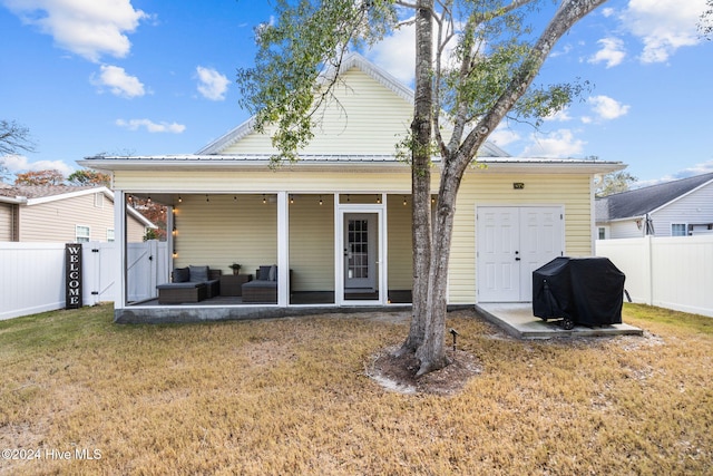 back of property with an outdoor living space, a yard, and a patio