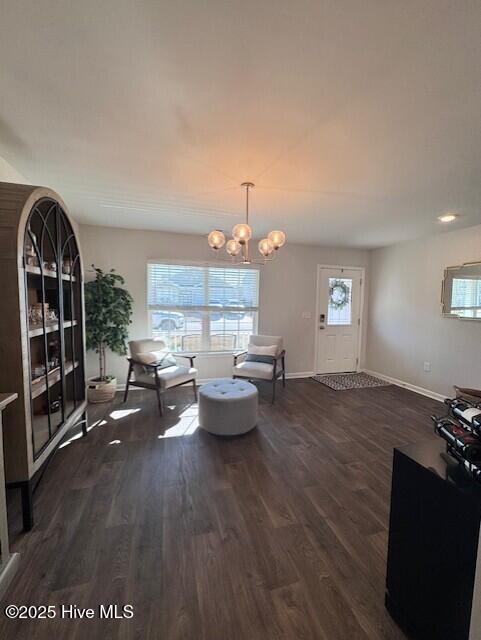 interior space featuring dark wood-type flooring and an inviting chandelier