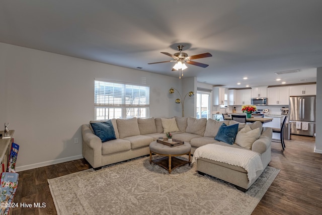 living room with ceiling fan and dark hardwood / wood-style flooring