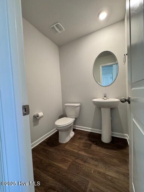 bathroom with wood-type flooring and toilet