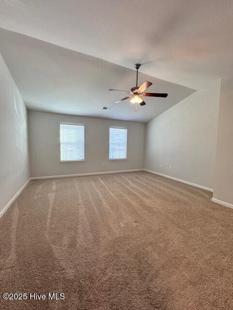 spare room featuring carpet, lofted ceiling, and ceiling fan