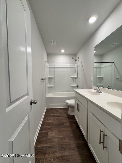 full bathroom featuring vanity, hardwood / wood-style floors, shower / washtub combination, and toilet