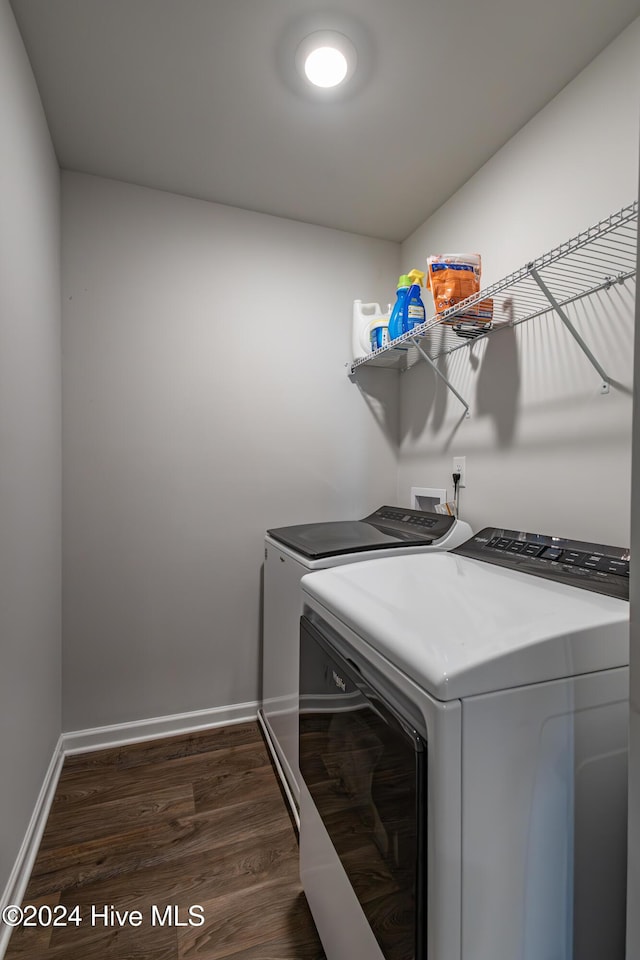 clothes washing area with dark hardwood / wood-style flooring and separate washer and dryer