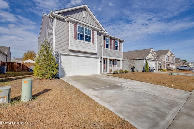 view of front of home with central AC, a garage, and a front lawn