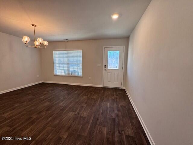 interior space with an inviting chandelier and dark hardwood / wood-style floors