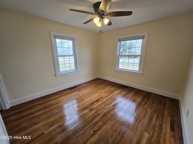 spare room featuring dark hardwood / wood-style flooring, a wealth of natural light, and ceiling fan