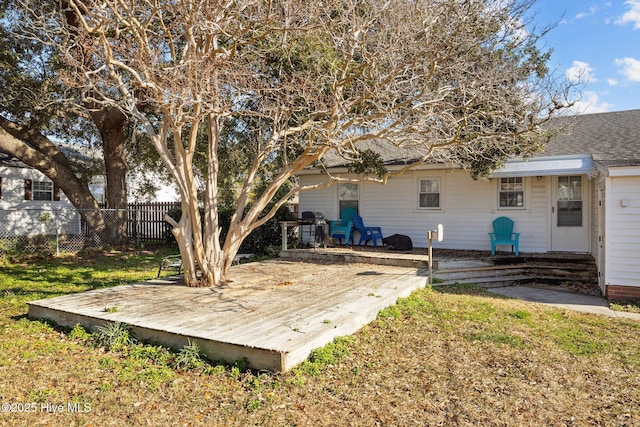 exterior space featuring a wooden deck and a lawn