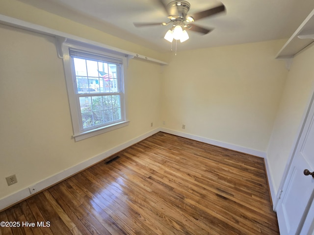 empty room with hardwood / wood-style floors and ceiling fan