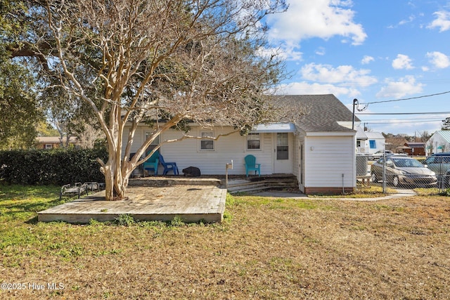 back of house featuring a wooden deck and a lawn