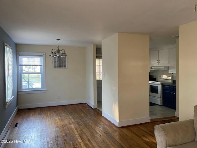 kitchen with an inviting chandelier, white cabinetry, range with electric stovetop, dark hardwood / wood-style floors, and decorative light fixtures