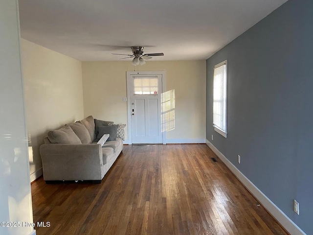 unfurnished living room with ceiling fan, dark hardwood / wood-style floors, and a healthy amount of sunlight