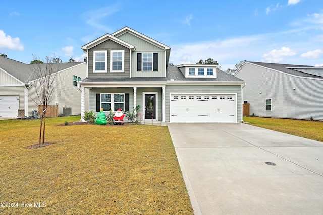 view of front facade featuring covered porch, a garage, a front lawn, and cooling unit