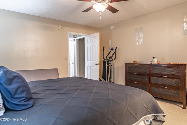 carpeted bedroom with a textured ceiling and ceiling fan