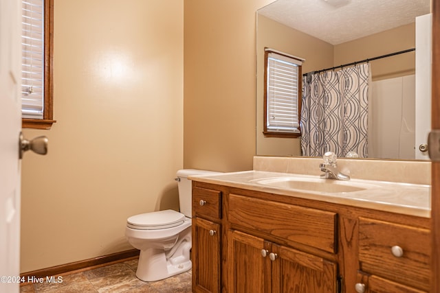 bathroom with walk in shower, vanity, a textured ceiling, and toilet