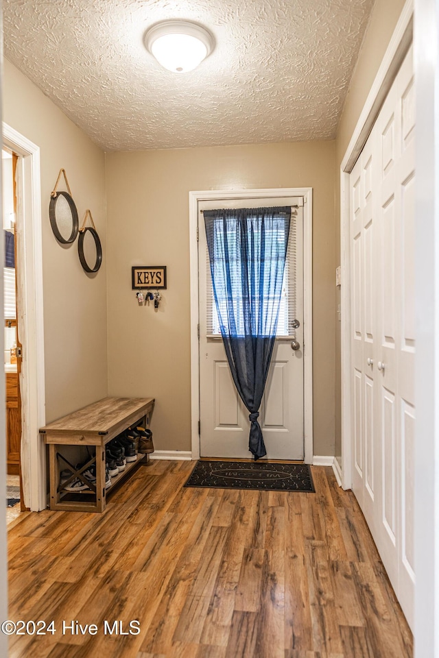 foyer featuring wood-type flooring and a textured ceiling