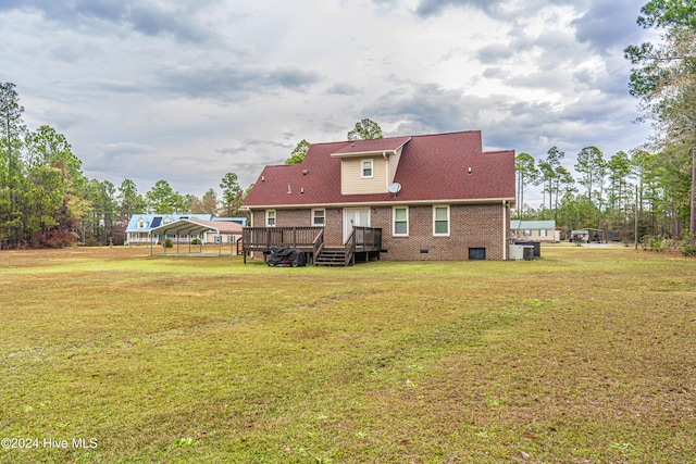 rear view of property featuring a carport, central AC unit, a yard, and a wooden deck