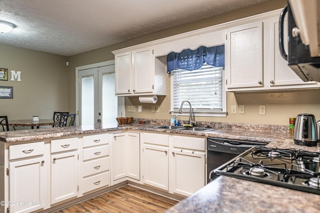 kitchen featuring kitchen peninsula, a textured ceiling, sink, light hardwood / wood-style flooring, and white cabinets