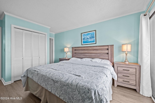 bedroom featuring a closet, crown molding, a textured ceiling, and light wood finished floors