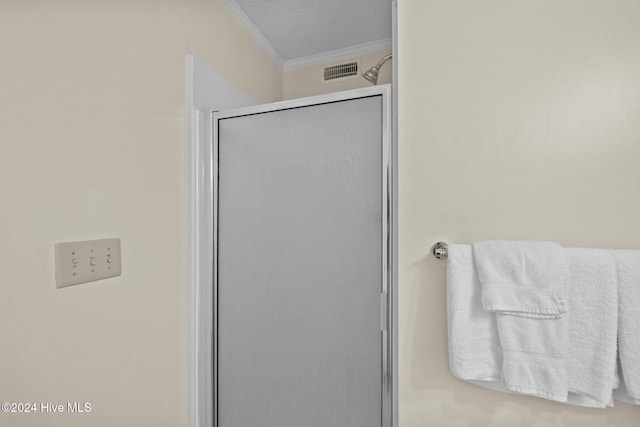 full bath featuring a stall shower, visible vents, crown molding, and a textured ceiling