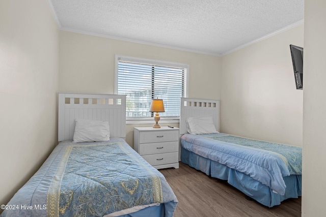 bedroom featuring ornamental molding, a textured ceiling, and hardwood / wood-style flooring